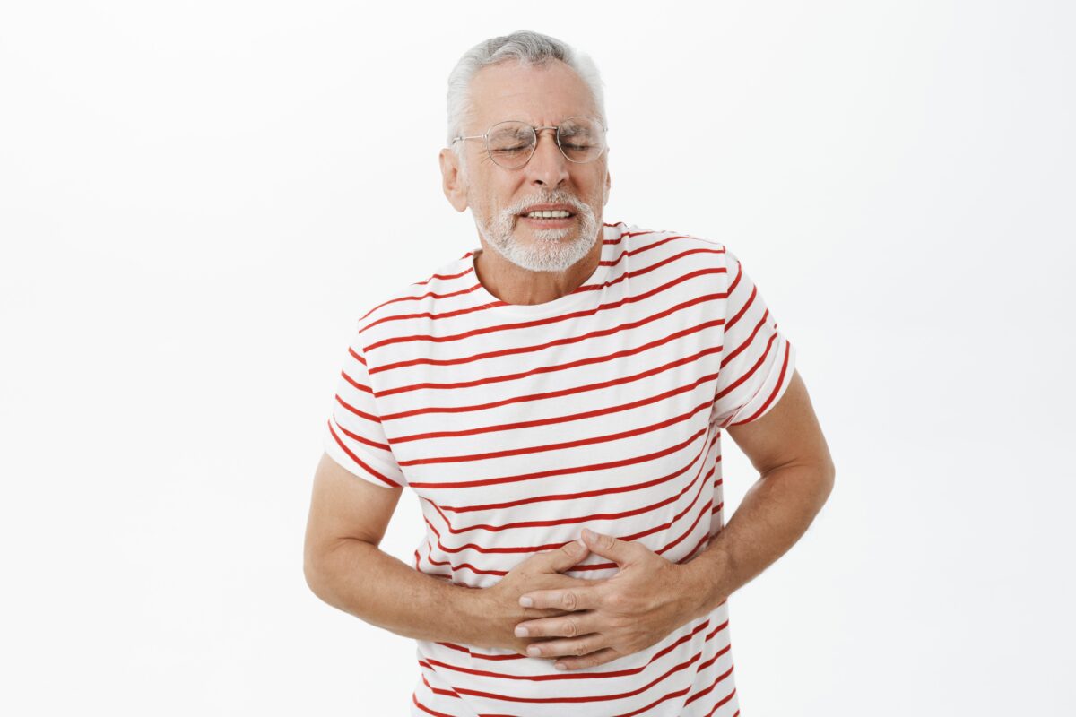 bearded old man in striped tshirt having constipation